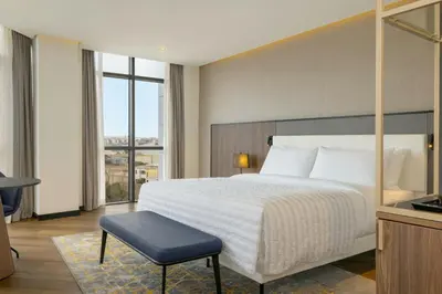 a hotel room with a bed and a chair in it at Le Meridien Casablanca in Casablanca