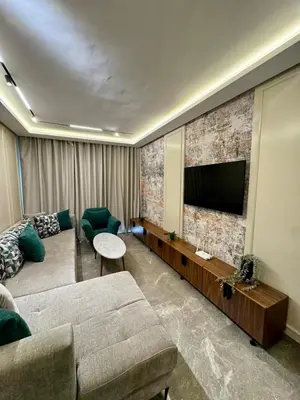 a living room with a couch and a flat screen tv at Domus Studio - Ambiance Zen au cœur de Casablanca in Casablanca