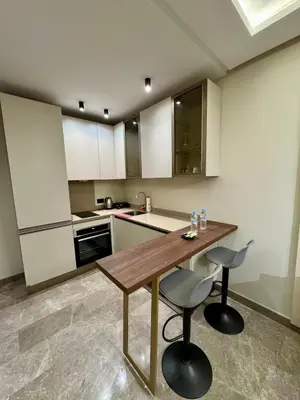 a kitchen with a wooden table and two chairs at Domus Studio - Ambiance Zen au cœur de Casablanca in Casablanca