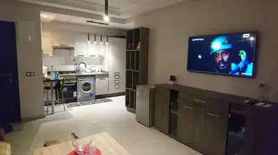 a living room with a tv on the wall of a kitchen at Cozy Appartement Relax in Mohammedia