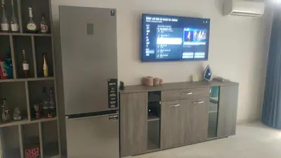 a bar with a tv on a wall with wine bottles at Cozy Appartement Relax in Mohammedia