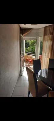 a dining room with a table and chairs and a balcony at Bahia golf beach bouznika in Bouznika