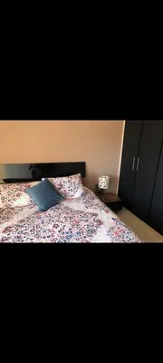 a bedroom with a bed with a blue pillow at Bahia golf beach bouznika in Bouznika