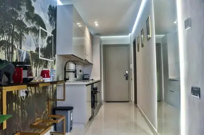 a kitchen with white appliances and a hallway at Studio de luxe Vue Mer corniche casablanca in Casablanca