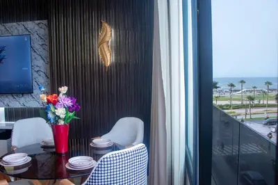a dining room table with a vase of flowers on it at Studio de luxe Vue Mer corniche casablanca in Casablanca