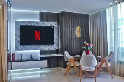 a dining room with a tv and a table and chairs at Studio de luxe Vue Mer corniche casablanca in Casablanca