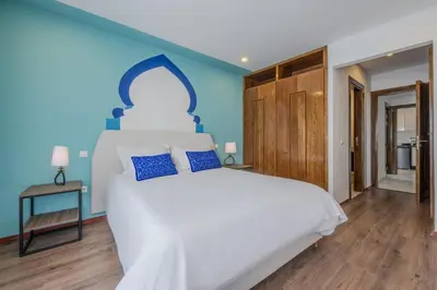 a bedroom with a large white bed with blue walls at CASA B l'hôtel in Casablanca