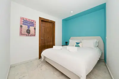 a white bed in a room with a blue wall at CASA B l'hôtel in Casablanca