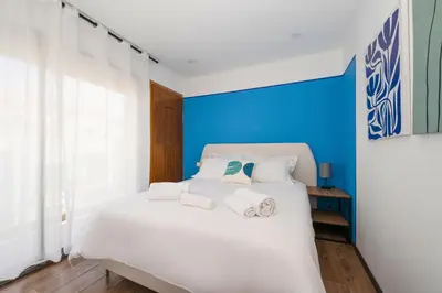 a bedroom with a white bed with a blue wall at CASA B l'hôtel in Casablanca