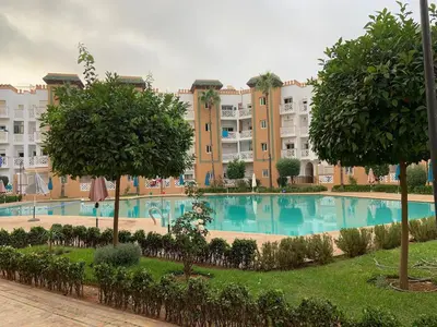 a large swimming pool in front of a large building at Al kawtar Vacation apartment in Mansouria in O Ben Slimane