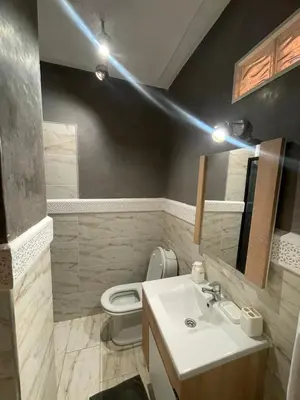 a bathroom with a white sink and a toilet at Al kawtar Vacation apartment in Mansouria in O Ben Slimane