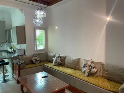 a living room with a couch and a table at Al kawtar Vacation apartment in Mansouria in O Ben Slimane