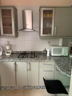 a kitchen with a stove and a microwave at Al kawtar Vacation apartment in Mansouria in O Ben Slimane