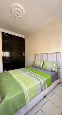 a bedroom with a large bed with green sheets at Charming home in Temara in Temara