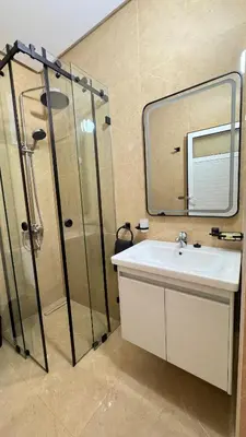 a bathroom with a sink and a shower with a mirror at Charming home in Temara in Temara