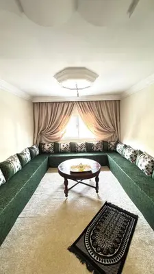 a living room with a green couch and a table at Charming home in Temara in Temara