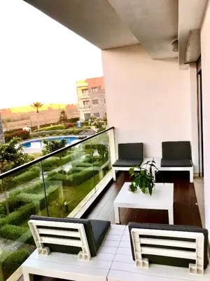a balcony with two chairs and a view of a pool at Garden Bay Luxe, Tamaris Bord de Mer in Casablanca