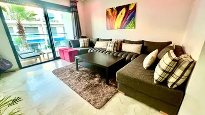 a living room with a couch and a coffee table at Garden Bay Luxe, Tamaris Bord de Mer in Casablanca