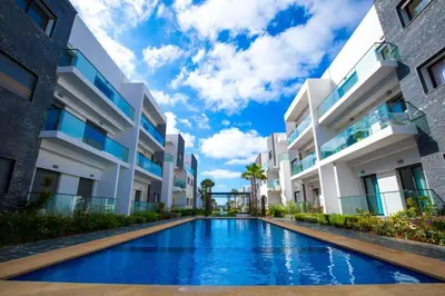 a swimming pool in front of a building at Garden Bay Luxe, Tamaris Bord de Mer in Casablanca
