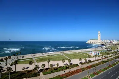 a view of the beach and the ocean with a lighthouse at Studio de charme face corniche de Casablanca in Casablanca