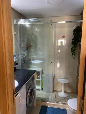 a bathroom with a shower and a washing machine at Appartement avec Terrasse, Piscine & Plage à Ola Blanca 2 in Sidi Rahal