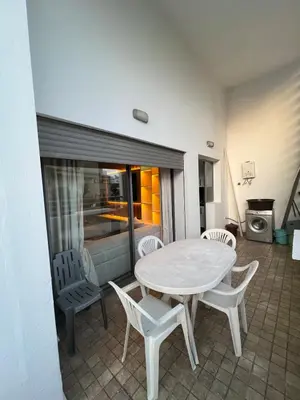 a white table and chairs in a room with a kitchen at Apartment in a residence in Pont Blondin