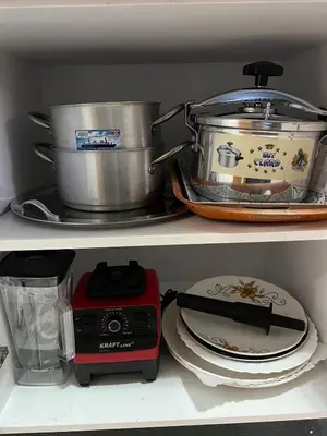 a kitchen shelf with pots and pans and a stove at Apartment in a residence in Pont Blondin