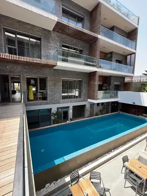 an apartment with a swimming pool in front of a building at Ocean park Pool, Spa and Welness suite in Casablanca