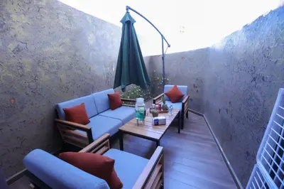 a balcony with a couch and a table and an umbrella at Luxe Ghandi Casablanca in Casablanca