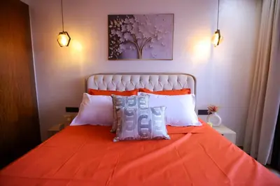 a bedroom with an orange bed with white pillows at Luxe Ghandi Casablanca in Casablanca