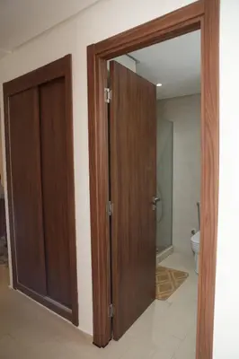 a bathroom with a wooden door and a toilet at Diana Ennour in Rabat