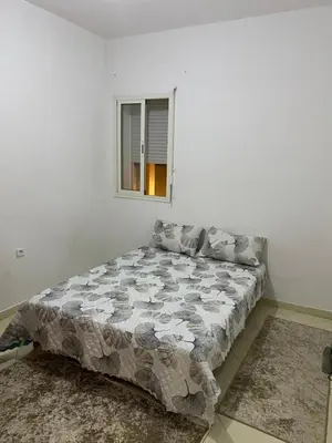 a bed in a white room with a window at Appartement à Skhirat in Skhirat