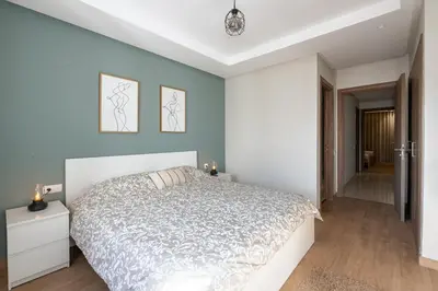 a bedroom with a white bed and blue walls at Chic, bright, 2 BR apartment, panoramic view in Temara