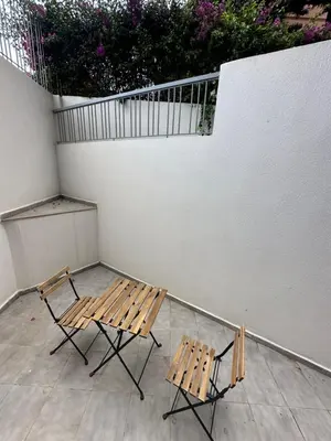 two wooden benches sitting next to a white wall at Joli appartement a casablanca in Casablanca
