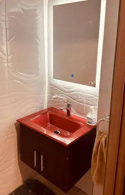 a bathroom with a red sink and a mirror at Elegant & spacious with a view in Mansouria