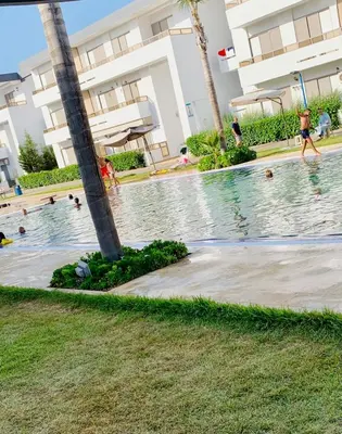 a swimming pool at a resort with people in the water at Elegant & spacious with a view in Mansouria