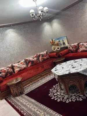 a living room with a red couch and a table at Elegant & spacious with a view in Mansouria