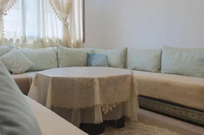a living room with a couch with a table at Maison Safran à Bouznika calme confort et authenticité à deux pas de la plage in Bouznika