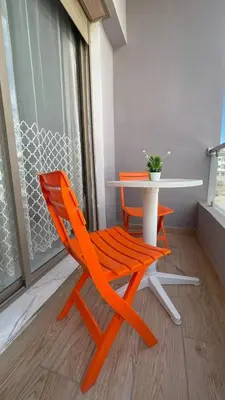 an orange chair sitting next to a table on a balcony at Maison Safran à Bouznika calme confort et authenticité à deux pas de la plage in Bouznika