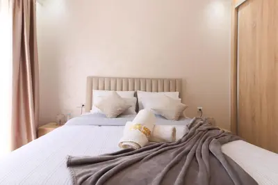 a bedroom with a large bed with white sheets and pillows at Maison Safran à Bouznika calme confort et authenticité à deux pas de la plage in Bouznika