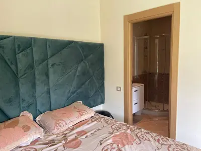 a bed with a large green headboard in a bedroom at Casabay T4 Sidi Rahal Vacation apartment in Sidi Rahal