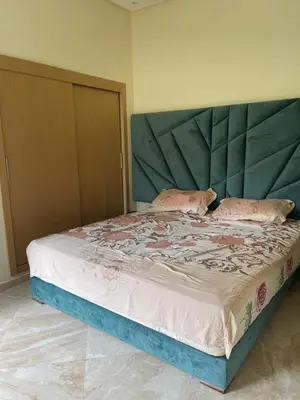 a bedroom with a large bed with a large headboard at Casabay T4 Sidi Rahal Vacation apartment in Sidi Rahal