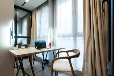 a desk with a laptop on it next to a window at charcho place in Les Camps