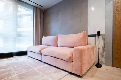 a pink couch in a room with a window at charcho place in Les Camps