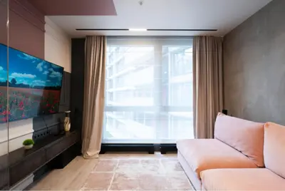 a living room with a couch and a large window at charcho place in Les Camps