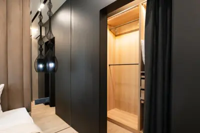 a bedroom with a black closet and a glass door at charcho place in Les Camps