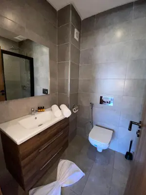 a bathroom with a white sink and a toilet at Natura Appartement Pool View by 7AV Hotels in Mohammedia