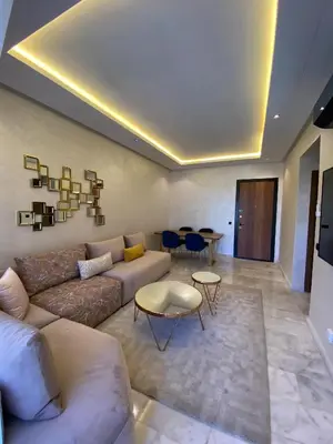 a living room with a couch and a table at Natura Appartement Pool View by 7AV Hotels in Mohammedia