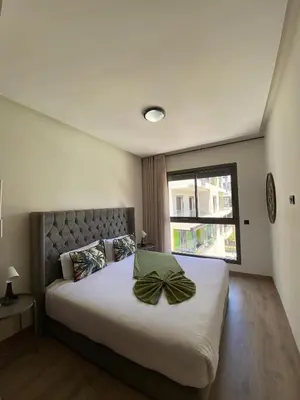 a bedroom with a large bed with a bow on it at Natura Appartement Pool View by 7AV Hotels in Mohammedia