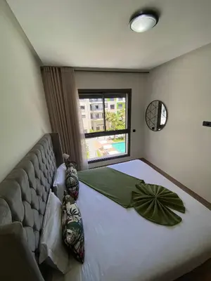 a bedroom with a large bed and a window at Natura Appartement Pool View by 7AV Hotels in Mohammedia